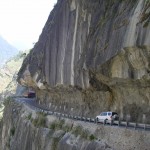 A bus and a truck driving on a very narrow, rocky road in the Himalayas | Yugo Driving School